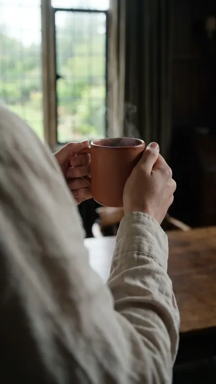 Pessoa de costas com a Caneca Terra junto à janela